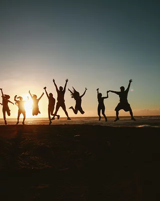 Groupe d'amis qui sautent devant un coucher de soleil