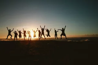 Gruppo di amici che saltano davanti al tramonto